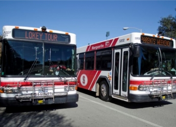 Two Marguerite shuttle buses parked side by side Two Marguerite shuttle buses parked side by side
