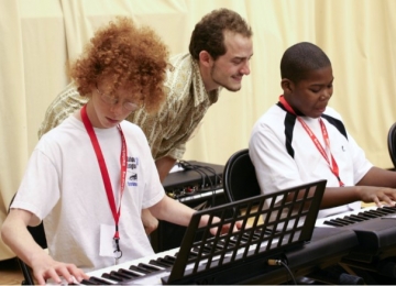 Teacher instructs student in Stanford Jazz class Teacher instructing a student in Stanford Jazz (2011) with another student in the foreground.